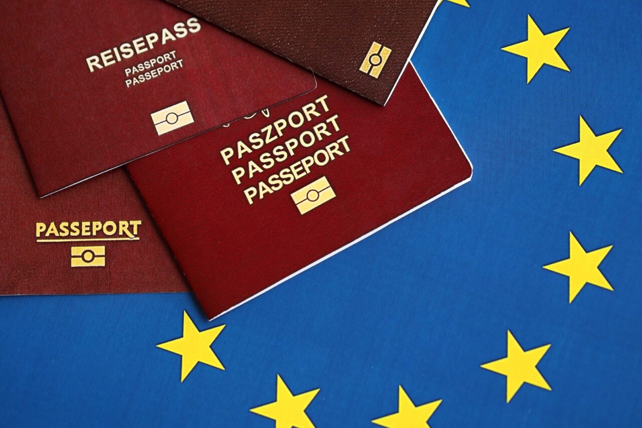 European union countries passports on blue EU flag close up. Portugal, German, French and Polish passports